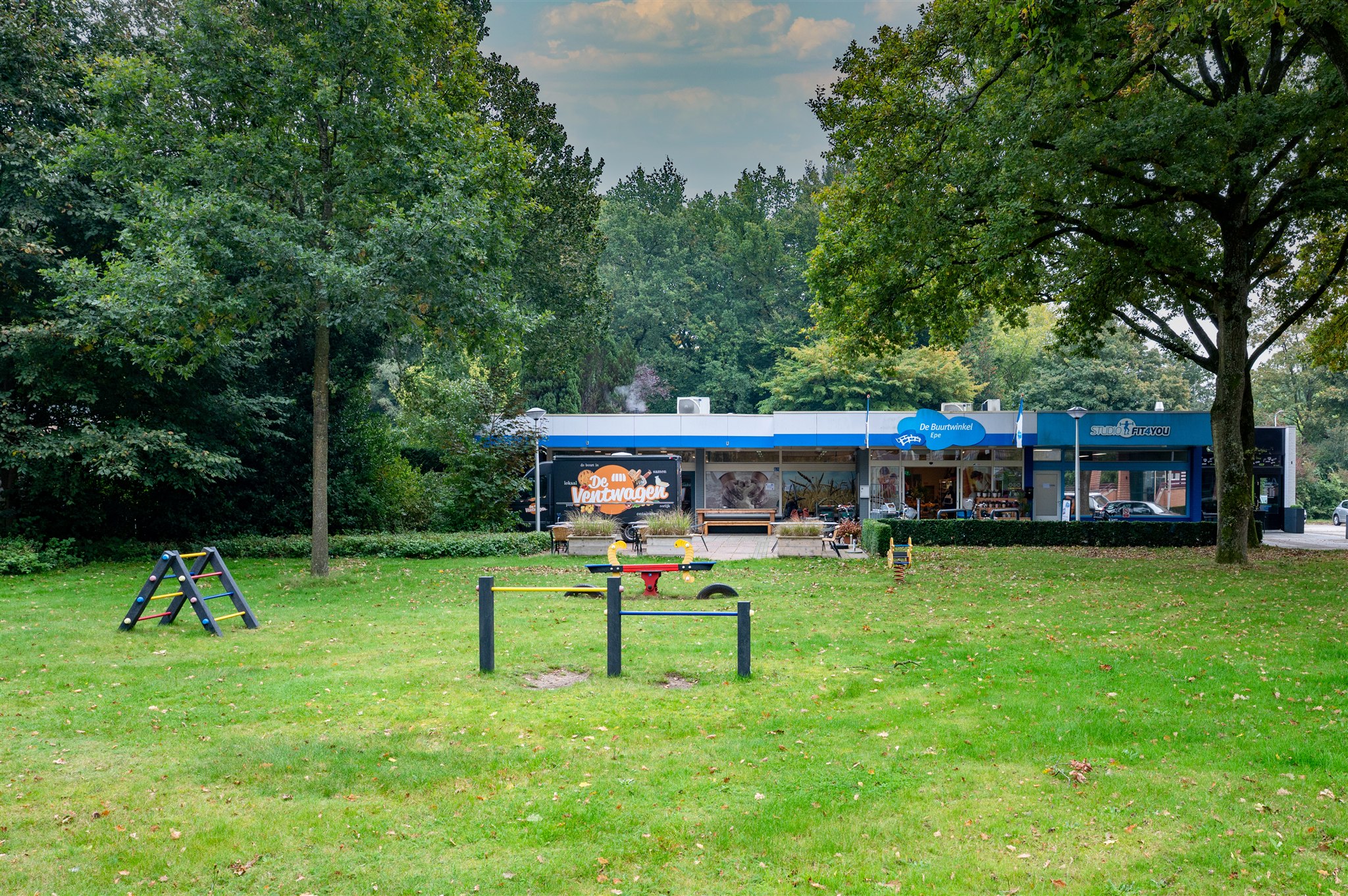 CHARACTER shot - distant view showing building integrated in green park environment with recreational facilities